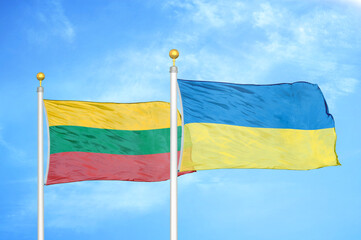Lithuania and Ukraine two flags on flagpoles and blue sky