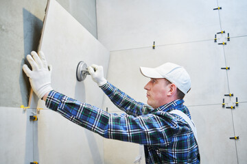 Tiler installing large format tile on wall. home indoors renovation