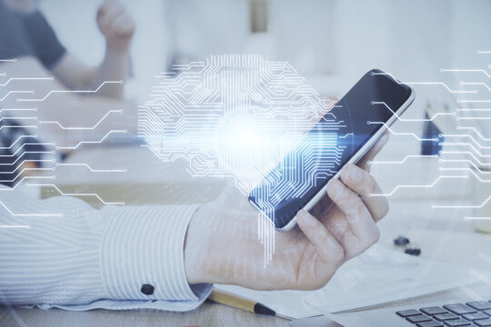 Double exposure of man's hand holding and using a digital device and brain hologram drawing. Data concept.