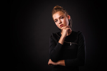 Fashion glamorous portrait of a girl in black dress on dark background. Elegant hairstyle, bright makeup and lip color.