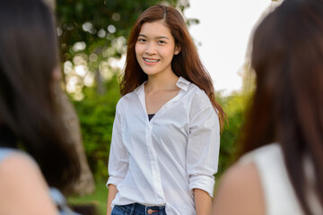 Three young Asian women as friends together at the park