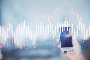 Double exposure of forex chart sketch hologram and woman holding and using a mobile device. Stock market concept.