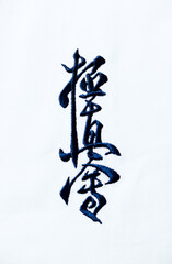 Kyokushinkai karate symbol on cotton background.  "Kyokushin" is a style of stand-up, full contact karate and is Japanese for "the ultimate truth". Top view. Copy space.  © Eugeniusz Dudziński
