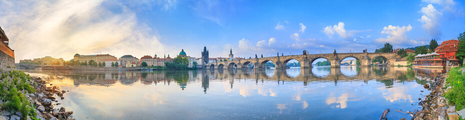 City summer landscape at sunrise - view of the Charles Bridge and the Vltava river in historical district of Prague, Czech Republic