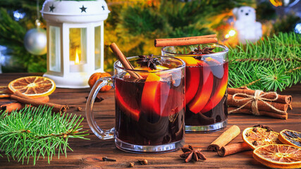 Christmas mulled red wine glühwine with aromatic spices and citrus fruits on a wooden rustic table, close-up. Traditional hot drink or festive cocktail at Christmas or New Year time