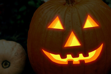 halloween pumpkin orange, carved jack lantern, terrifying fiery smile in the dark