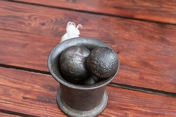 pair of heavy shells lay in an iron glass for measuring gunpowder