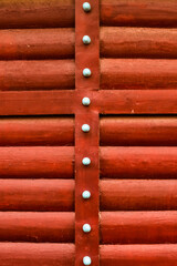 red logs are folded into a vertical panel with an iron bar bolted