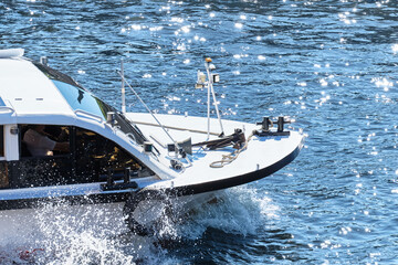 Sea boat sails with splashing water in summer