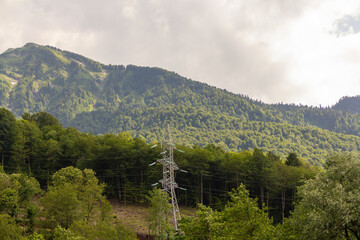 valley of green high mountain electric tower laying electricity in hard to reach places