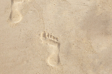 footprints in the sand of women's feet in the sand goes into emptiness
