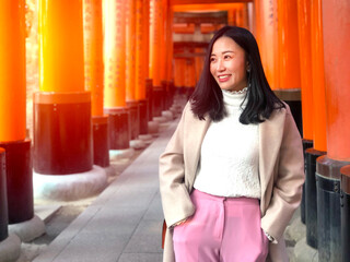  Young woman tourist travel Kyoto, Japan at Fushimi Inari Shrine gate at sunrise