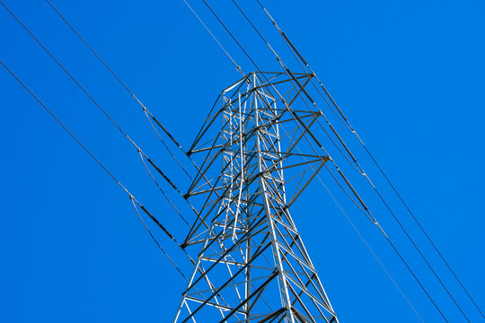 High voltage transmission tower (power tower, electricity pylon, steel lattice tower) with parallel single-circuit lines in the blue sky