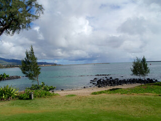 Path to Beach at Kahului Bay with trees, and clouds in the sky