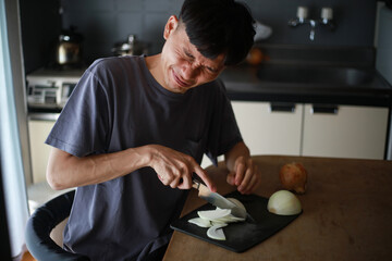 タマネギを切り目が痛む男性