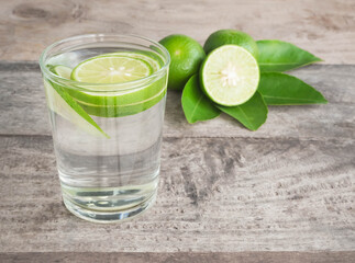 Lime juice in glass with fresh sliced lime  on wood background. 