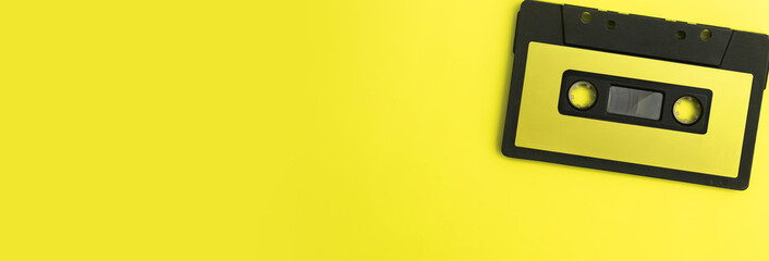 Fototapeta premium panoramic - black cassette tape with yellow background