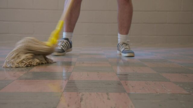 Caucasian Janitor Man Mopping Tile Floor with Cleaning Sanitation Mop