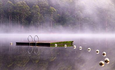 Floating pontoon in a lake on a foggy morning