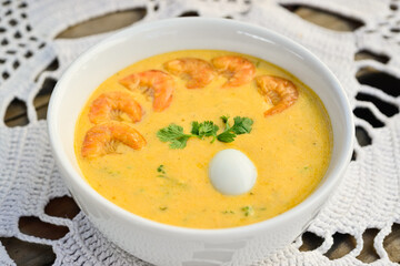 Brazilian gastronomy. Fish broth with shrimps and quail egg.