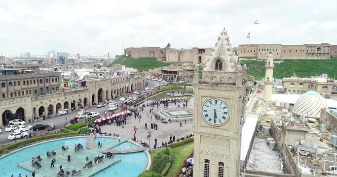 Aerial drone view of city of Erbil. Clock tower, buildings, roads, people.
