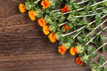 焦げ茶色のテーブルの上の紅花の花々