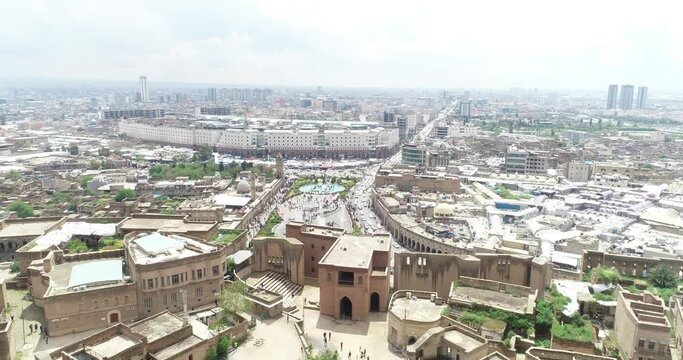 Aerial drone view of city of Erbil. Clock tower, buildings, roads, people.
