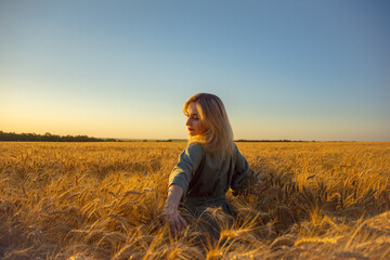 Outdoor photoshoot of a young girl in the field at sunset