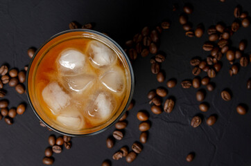 Glass of filter coffee with milk on a dark board.