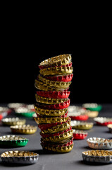 Large pile of beer bottle caps on black dark