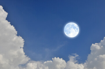 Romantic and charming full moon in blue sky with white clouds