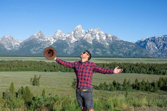 Portrait of young man posing with a view of Grand Tetons in Wyoming, USA