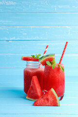 Watermelon smoothie drinks in the glass on blue wooden background with copy space.