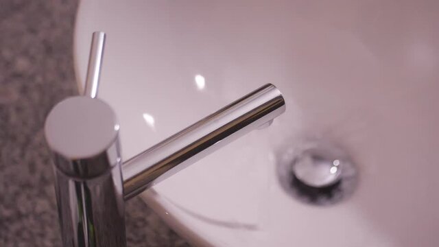 open faucet droping water in lavatory on bathroom slow motion