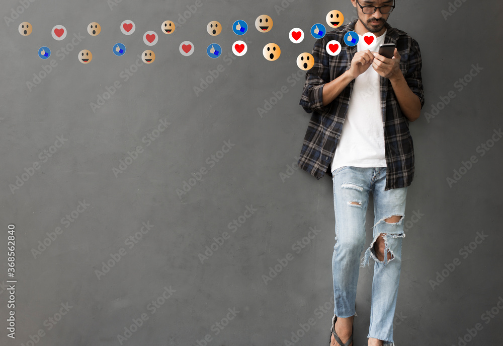 Wall mural Social media concept with young man using smartphone with giving icon comment during watching  live with copy space