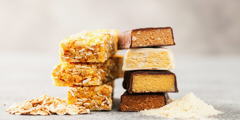 Different Energy protein bars and oatmeal bars on grey background.   Set of energy, sport,...