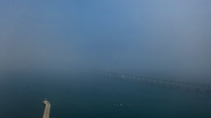 Aerial photography of China’s seaside second-tier cities under clouds and fog, and the...