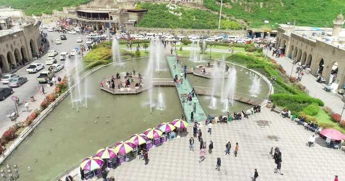 Aerial drone view of city of Erbil. Clock tower, buildings, roads, people.