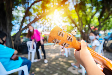 Asian students studying music Musical instruments as ukulele, learning outside the classroom