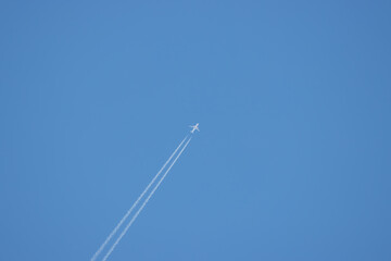  passenger plane flies high in the sky and forms a contrail