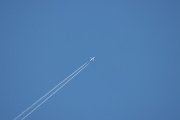  passenger plane flies high in the sky and forms a contrail