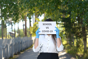 A schoolgirl against a green tree. A high school student stands in a school alley. A girl in an medical gloves holds a leaflet with an inscription.