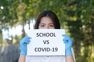 A schoolgirl against a green tree. A high school student stands in a school alley. A girl in an medical gloves holds a leaflet with an inscription.