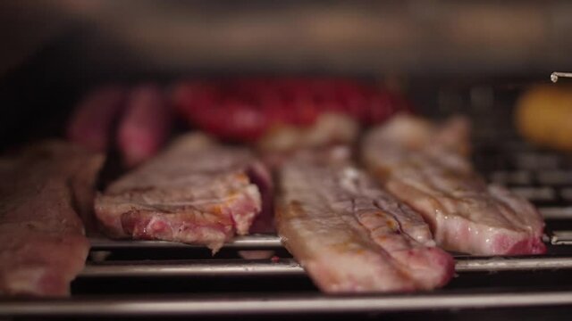 cooking grilling steak sausage on a grill  slow motion
