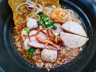 A Bowl of Hot Spicy and Sour Noodles with Pork and Meat Balls