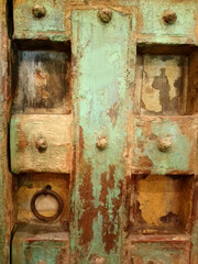 Vintage rustic looking wooden green door with artistic details