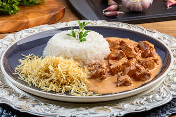 Chicken stroganoff with rice and potato straw.