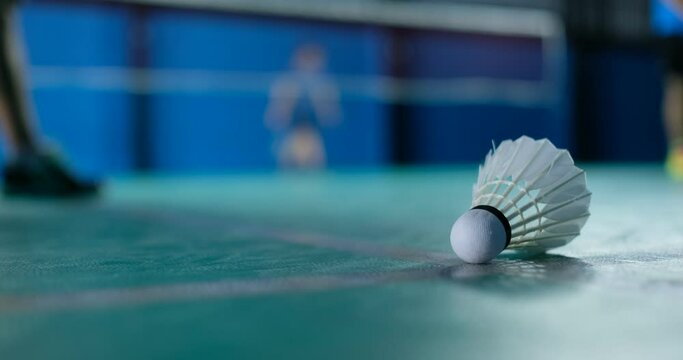Badminton shuttlecock on a green floor 
