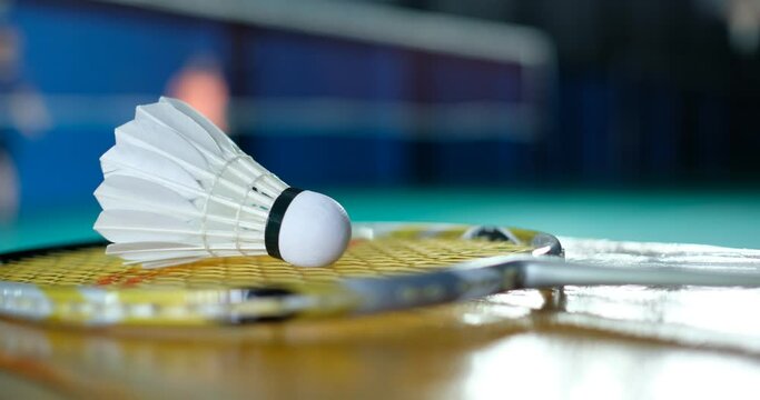 Badminton shuttlecock and racket with blur player background
