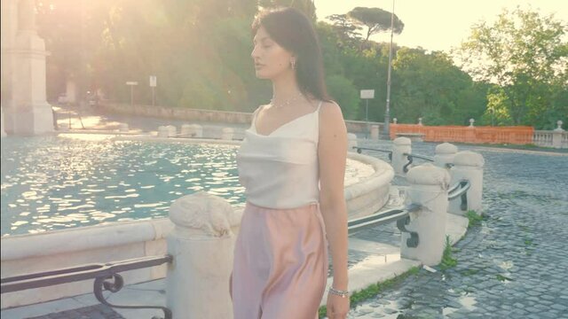 young haughty woman walking around the janiculum fountain